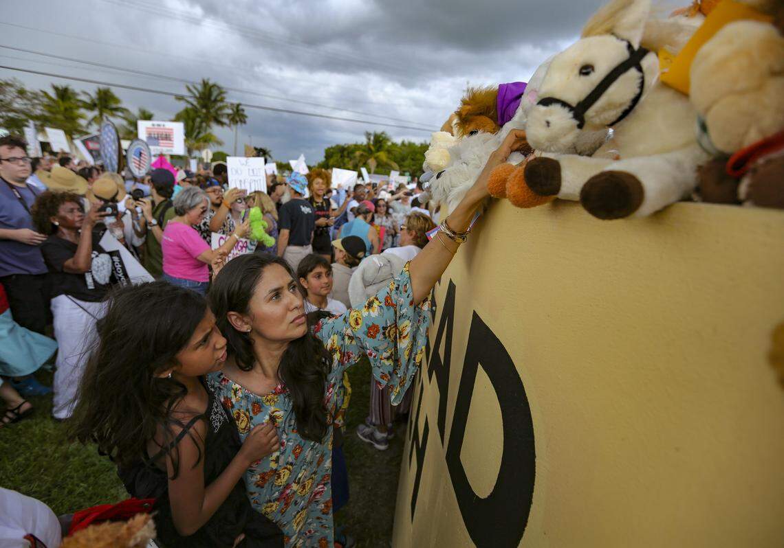 Protesters scramble to get out of the rain after placing stuffed animals along the wall outside of the Homestead shelter for migrant children in Homestead on Saturday, June 23, 2018.