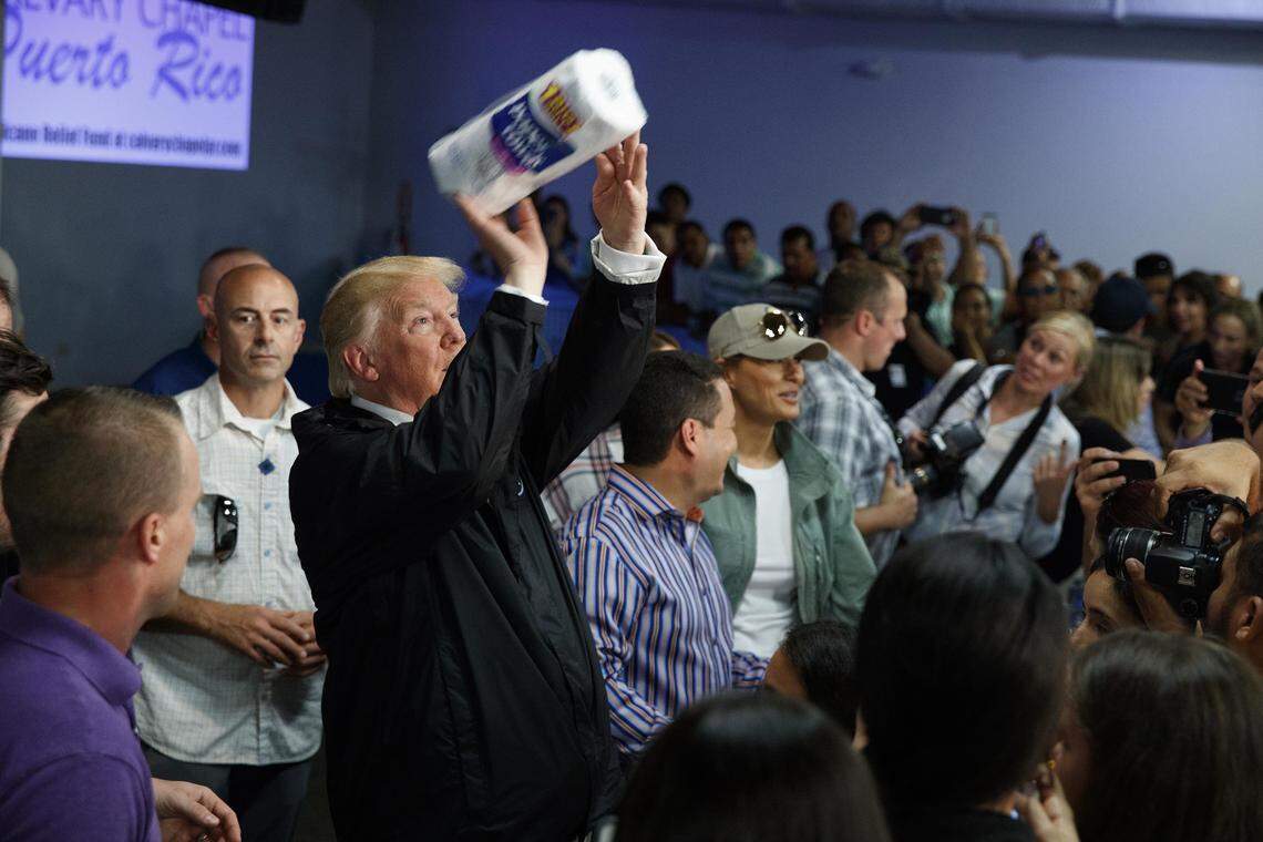 President Donald Trump tosses paper towels into a crowd as he hands out supplies at Calvary Chapel on Oct. 3, 2017, in Guaynabo, Puerto Rico, following Hurricane Maria.