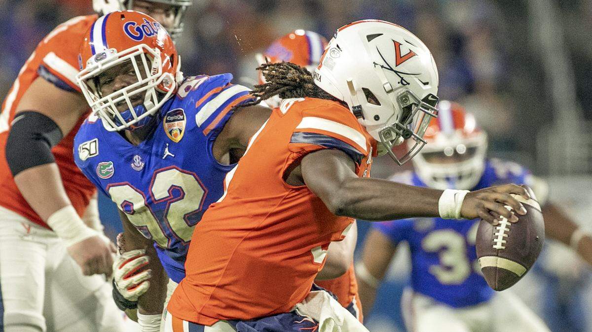 Florida Gators defensive lineman Jabari Zuniga (92) puts pressure on Virginia Cavaliers quarterback Bryce Perkins (3) in the second quarter as the Florida Gators play the Virginia Cavaliers during the Capital One Orange Bowl at Hard Rock Stadium in Miami Gardens on Monday, December 30, 2019.