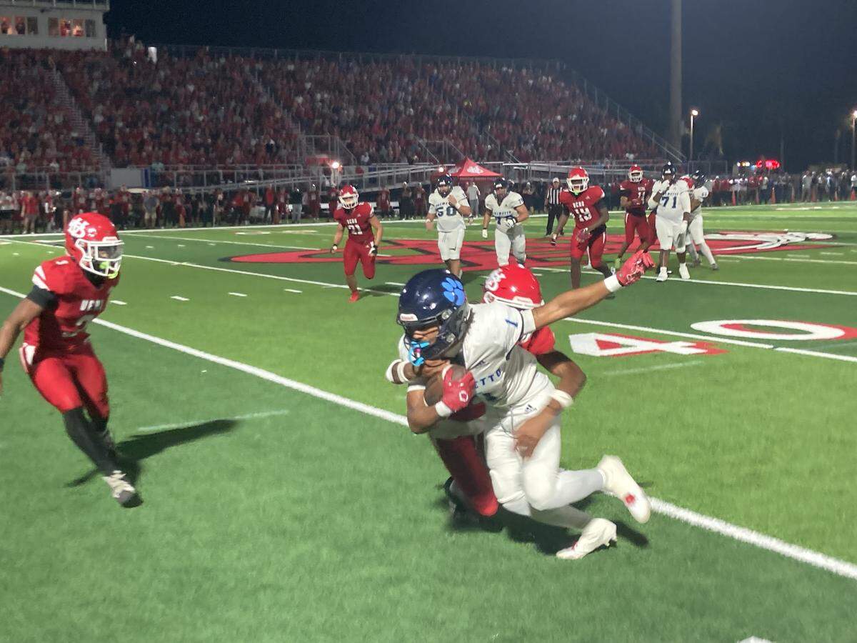 Palmetto receiver Conneilus Miller Jr. digs for more yards as Vero Beach defenders attempt to bring him down during Friday’s Class 7A state semifinal in Vero Beach, Fla.