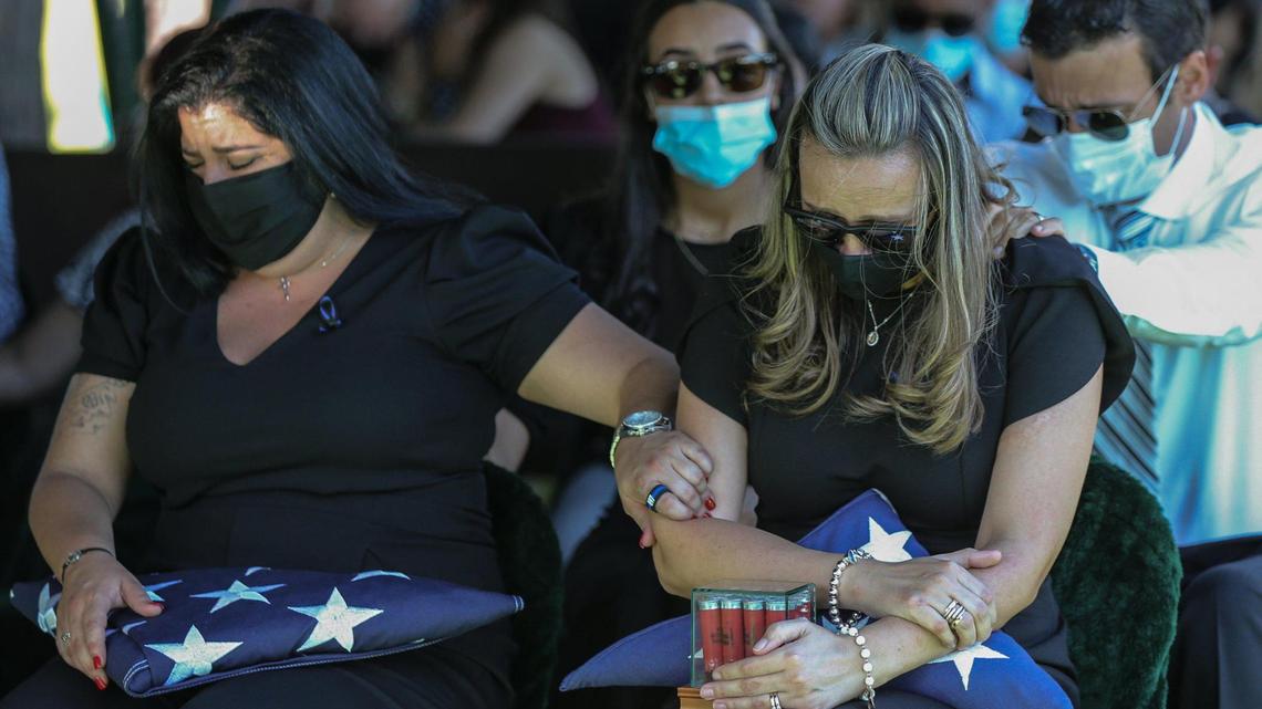 Luisa Febles, the wife of Florida Highway Patrol Trooper Lazaro R. Febles, is comforted by her sister-in-law Bianca Gonzalez and brother in-law Jorge Botero at Woodlawn Park Cemetery in southwest Miami-Dade on Friday, Aug. 20, 2021. Febles, who served more than 11 years with the Florida Highway Patrol in Troop E Miami, died of complications from COVID-19.