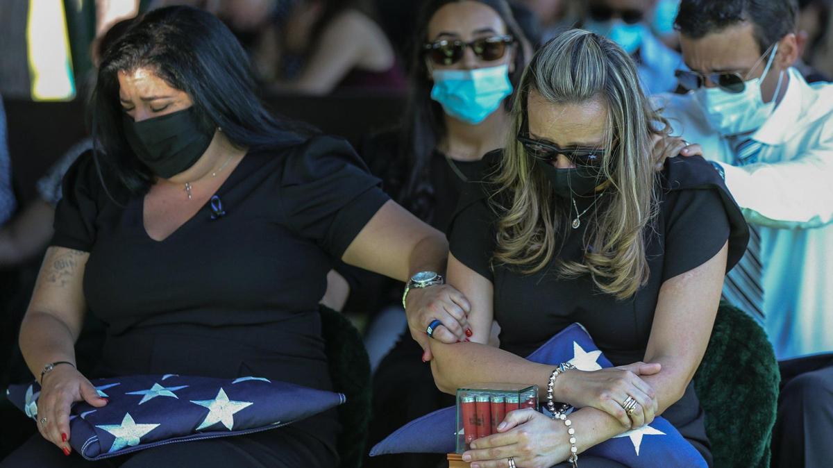 Luisa Febles, derecha, esposa del policía de la Patrulla de Caminos de Florida Lazaro R. Febles, es consolada por su cuñada Bianca González y su cuñado Jorge Botero en el cementerio Woodlawn Park en el suroeste de Miami-Dade el 20 de agosto. Febles murió de complicaciones por COVID-19.