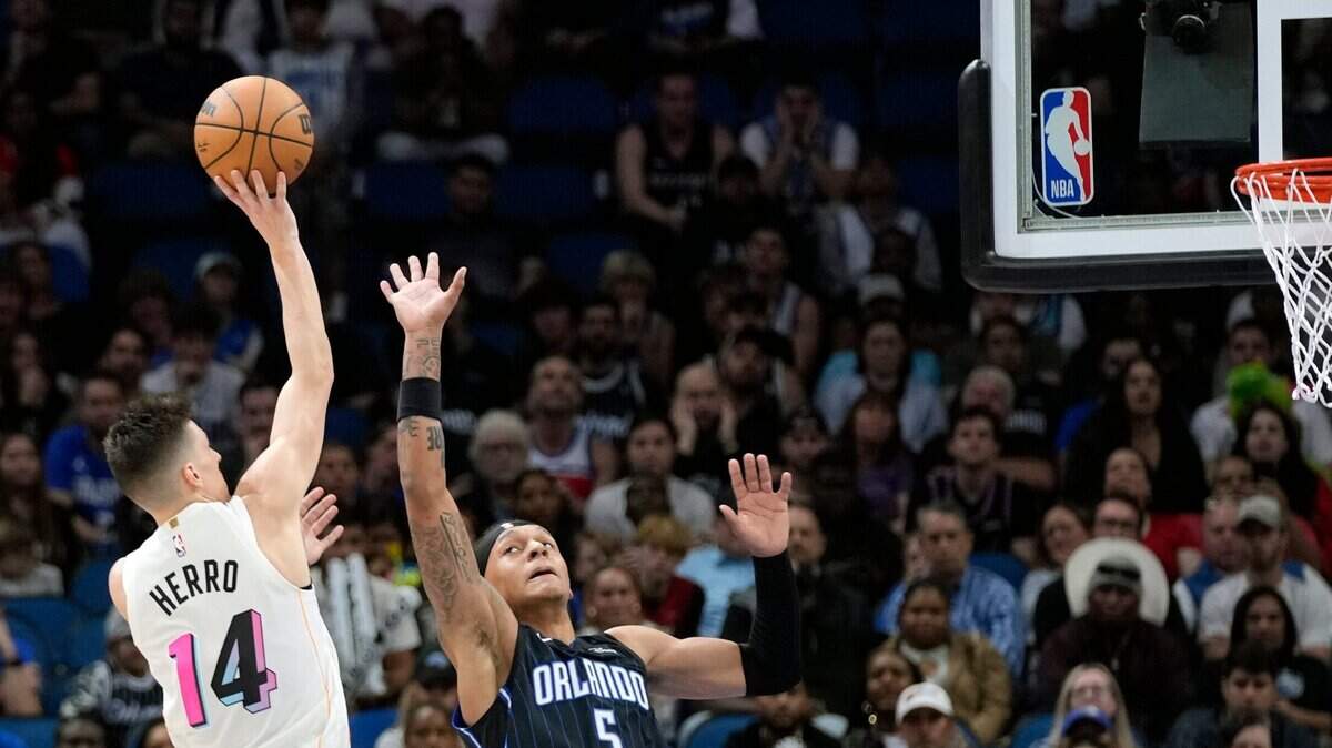 Miami Heat’s Tyler Herro (14) makes a shot over Orlando Magic’s Paolo Banchero (5) during overtime of an NBA basketball game, Saturday, Feb. 11, 2023, in Orlando.