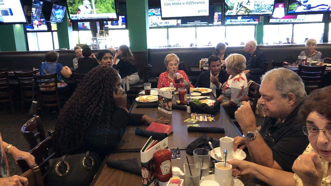 Florida Senator Daphne Campbell, D-North Miami Beach, makes a call at a Duffy’s where she and opponent Jason Pizzo (seen kneeling and speaking) answered questions from voters.