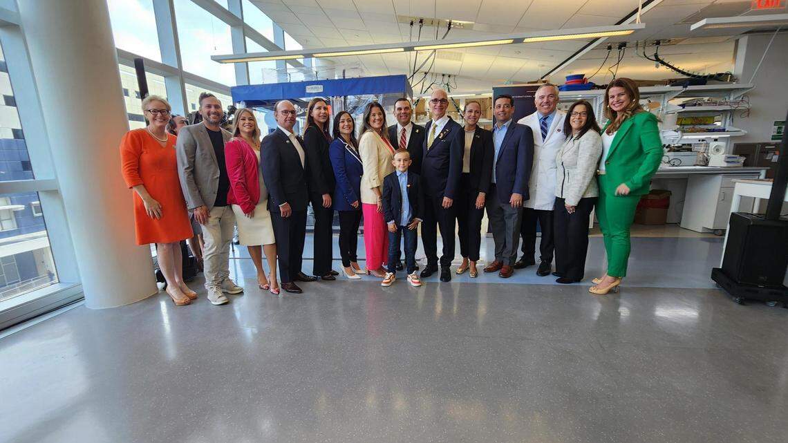 Logan (center), surrounded by representatives from FIU, Nicklaus Children’s, Live Like Bella and elected officials to celebrate the recent research collaboration.