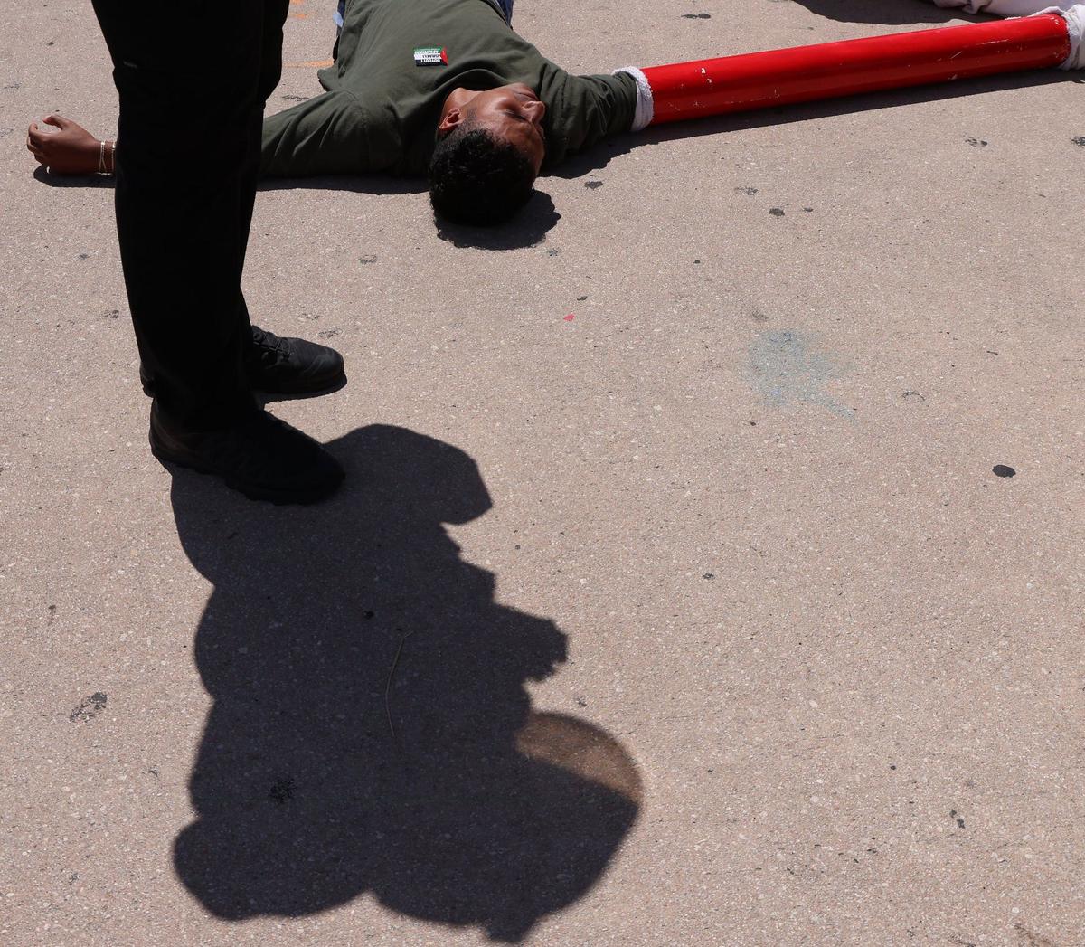 About seven people were detained and lay on the hot sidewalk after blocking the intersection of 3rd Street and northbound Biscayne on Monday, April 15, 2024, in downtown Miami, Florida.