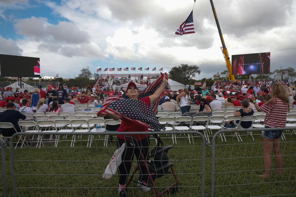 Miami resident Nancy Orozco waves scarves of the American flag and tries to get the attention of cameras as she arrives at her first political rally. On Sunday, November 6, 2022 former President Donald Trump and a collection of other national and local Republicans campaigned with U.S. Sen. Marco Rubio at the Youth Fairgrounds in Miami.