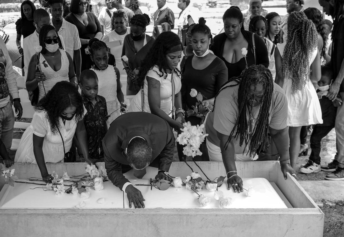 Mourners grieve and lay flowers on the casket of Nickolas Amos Calderon, who was buried at Lincoln Memorial Park.