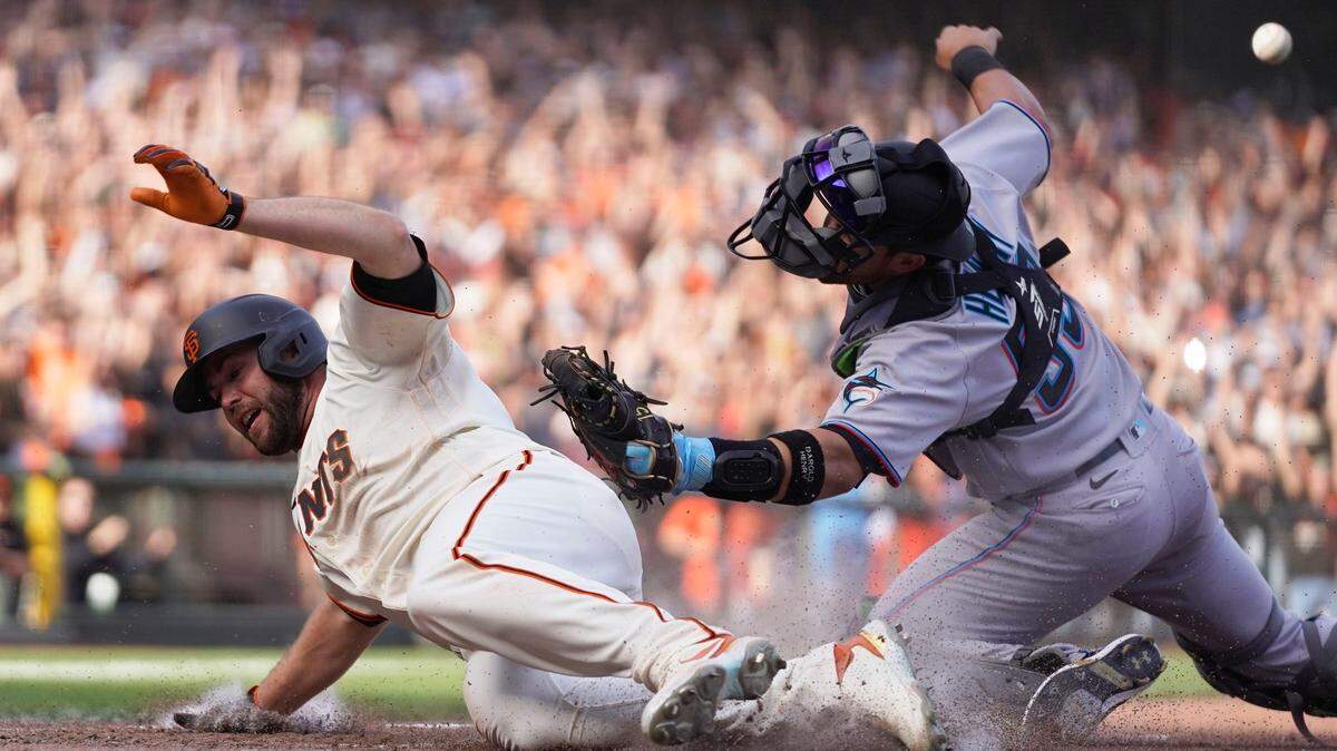 San Francisco Giants’ Darin Ruf scores at home plate as Miami Marlins catcher Payton Henry looks on in the 10th inning of a baseball game Friday, April 8, 2022, in San Francisco. Ruf scored after the Giants’ Austin Slater doubled to left field. San Francisco won the game 6-5.