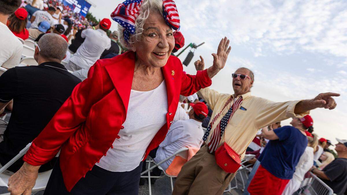 Trump supporters dance while waiting for former President Donald Trump to speak at a rally at Trump National on Tuesday, July 9, 2024, in Doral, Fla.