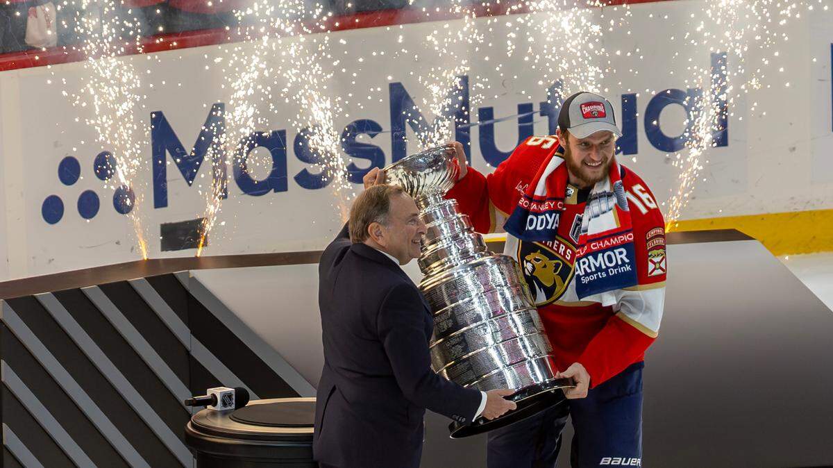 NHL Commissioner Gary Bettman (left) presents Florida Panthers center Aleksander Barkov (16) with the Stanley Cup after the Panthers defeated the Edmonton Oilers in Game 7 of the NHL Stanley Cup Final at the Amerant Bank Arena on Monday, June 24, 2024, in Sunrise, Fla.