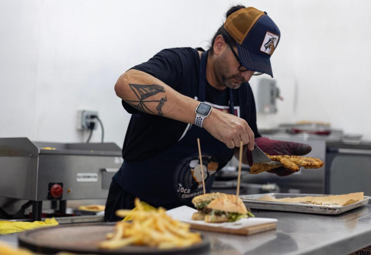Christian Fernández, copropietario de Karnitas 71st, en Miami Beach, preparando una Mila Messi, un plato temático de Lionel Messi que se hace con pechuga de pollo empanizada cubierta con huevos fritos y papas fritas, en una imagen del 12 de julio de 2023. Lauren Witte lwitte@miamiherald.com