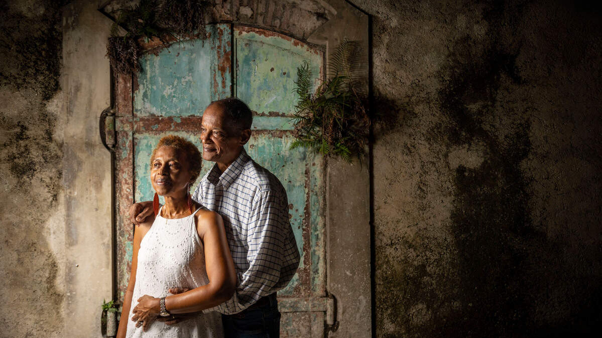 Georges Boursiquot and his wife Marguerite Baril-Boursiquot in front of one of many empty old coffee warehouses across the street from their boutique hotel L’auberge Du Vieux Port on Rue du Commerce in Jacmel, Haiti. The retired couple moved back to Haiti a decade ago from New York to open their now struggling hotel.