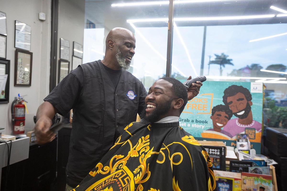 Barber Michael Stephens cuts Jefferson Noel‘s hair at Topcuttaz barbershop in Miami Gardens.