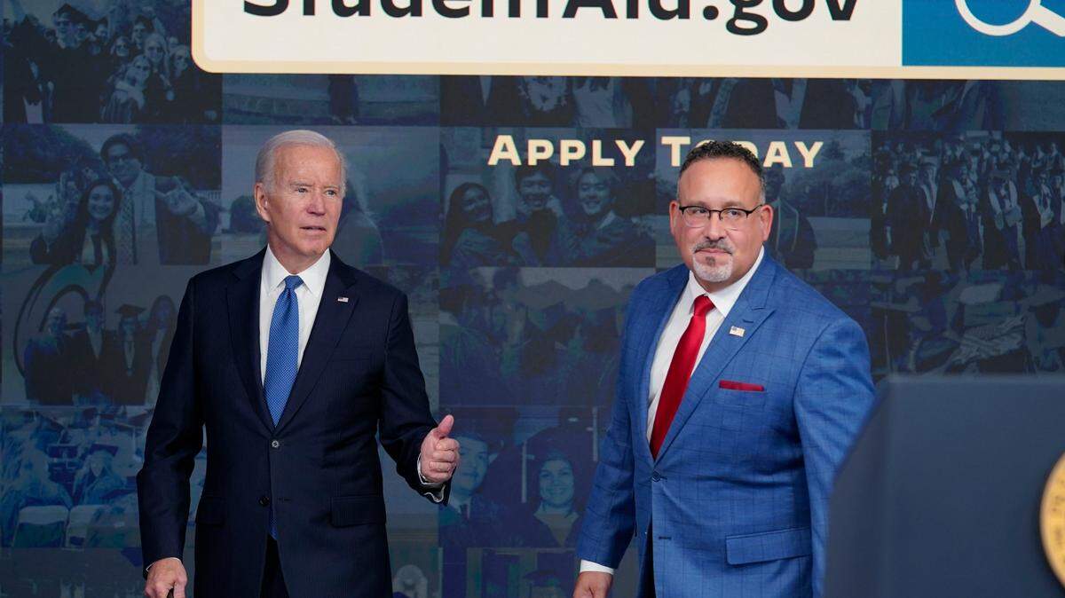 President Joe Biden answers questions with Education Secretary Miguel Cardona as they leave an event about the student debt relief portal beta test in the South Court Auditorium on the White House complex in Washington, Oct. 17, 2022.