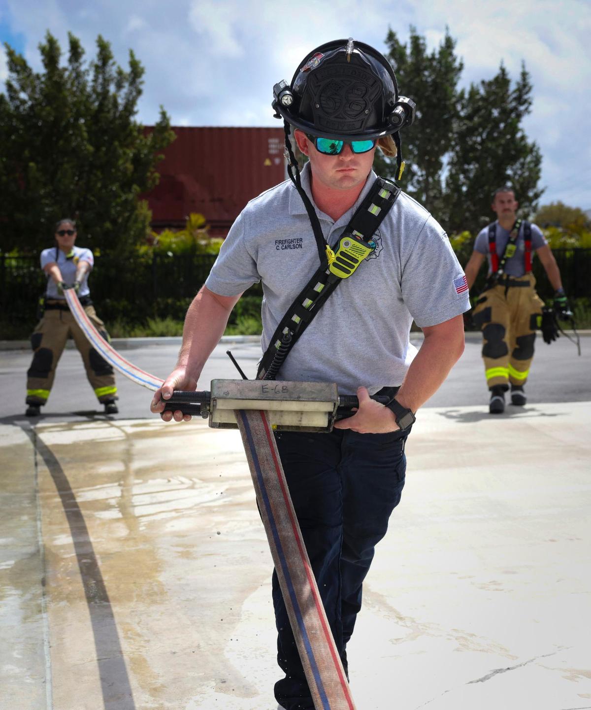 Firefighter Chris Carlson, center, rolls up a hose with the help of Lt. Veronica Cordoba, back left, and Jared Lago, back right, during a shift training exercise on Thursday, April 3, 2025, at Dolphin Station 68 in Sweetwater, Florida.