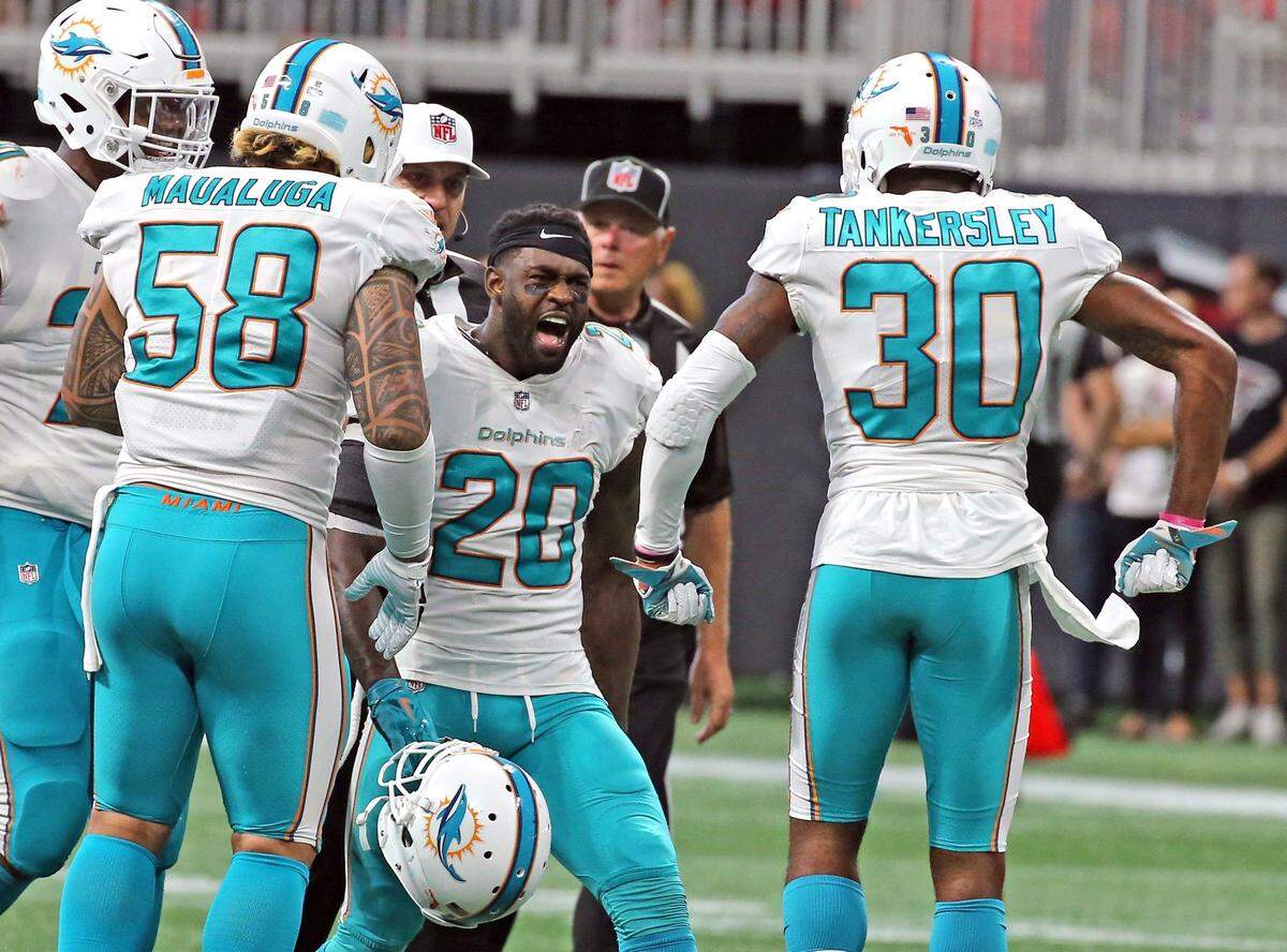 Miami Dolphins Cordrea Tankersley (30) and Reshad Jones (20) celebrate at the end of the fourth quarter on the field after Jones interception to defeat the Atlanta Falcons at the Mercedes-Benz Stadium in Atlanta, Georgia, October 15, 2017.