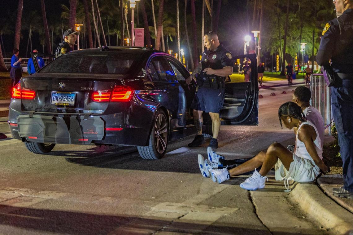 Two men are handcuffed by Miami Beach police officers on Ocean Drive at night during spring break in Miami Beach, Florida, on Friday, March 21, 2025.
