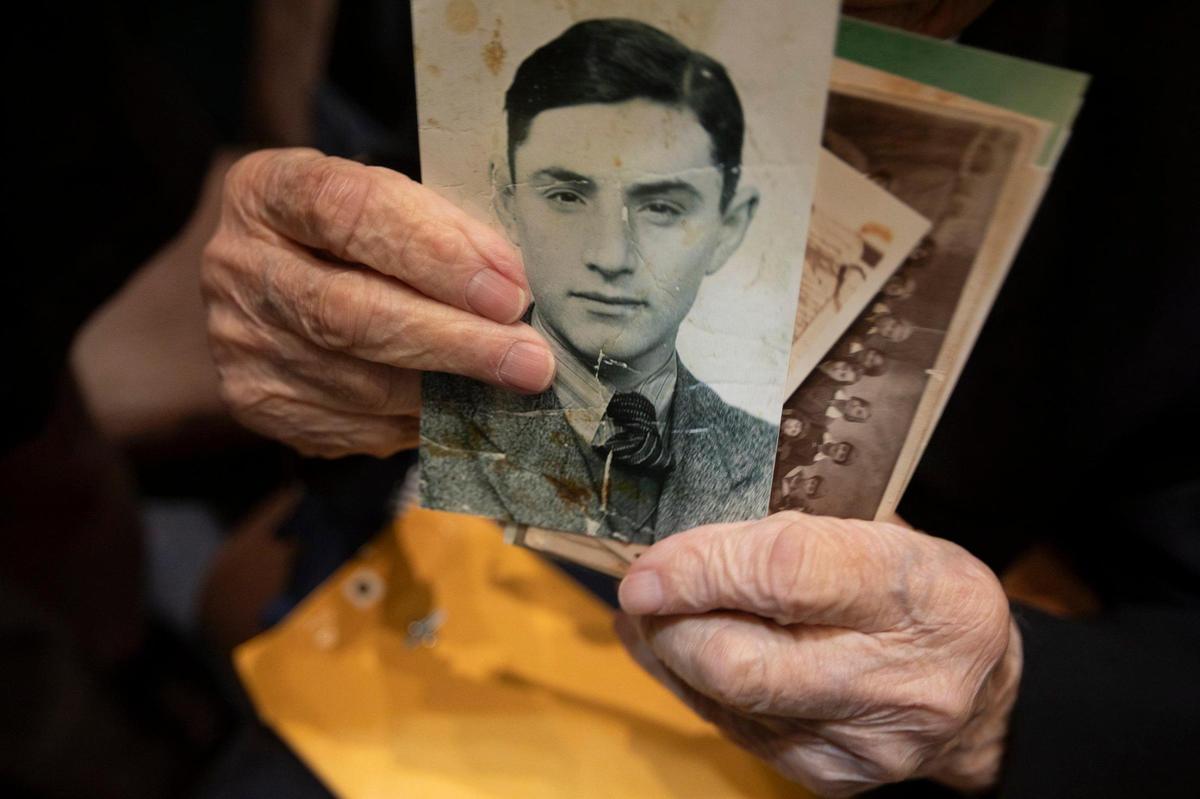 Jack Waksal, a Holocaust Survivor, shares photographs from his youth during a community commemoration of Kristallnacht, also known as the Night of Broken Glass.