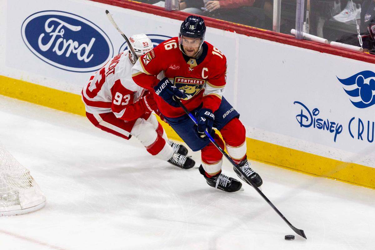 Florida Panthers center Aleksander Barkov (16) controls the puck while chased by Detroit Red Wings right wing Alex DeBrincat (93) during the first period of an NHL game at Amerant Bank Arena on Thursday, April 10, 2025, in Sunrise, Fla.
