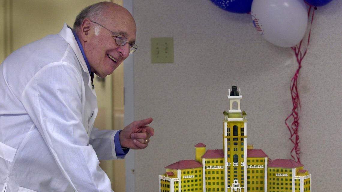 Dr. Lawrence M. Fishman, then-associate chief of staff for research at the Miami Veterans Affairs Medical Center, kids around with some of colleagues trying to taste a specially commissioned cake in the form of a three-dimensional replica of the historic structure of the Coral Gables Veteran Hospital-Biltmore Hotel. Photo taken: May 2, 2003. 