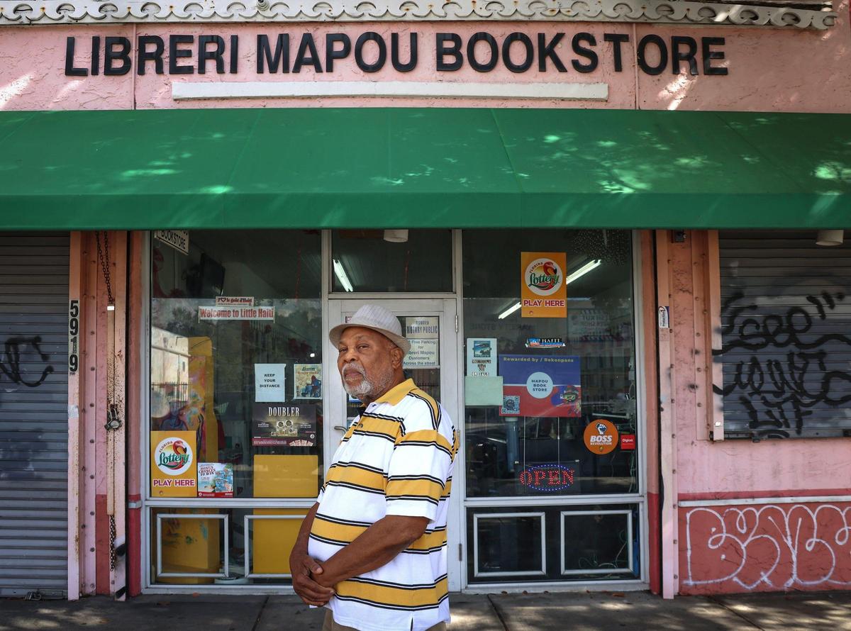 Poet and playwright Jean-Marie Denis, who goes by the pen name Jan Mapou, stands outside his bookstore and cultural center, a longtime institution in Miami’s Little Haiti neighborhood. Denis says the foreclosure sale to developers of an extensive portfolio of Little Haiti properties is causing anxiety amid a severe economic downturn caused by the COVID-19 pandemic and the city’s virtual closure of the adjacent Caribbean Marketplace and Haitian Cultural Center.