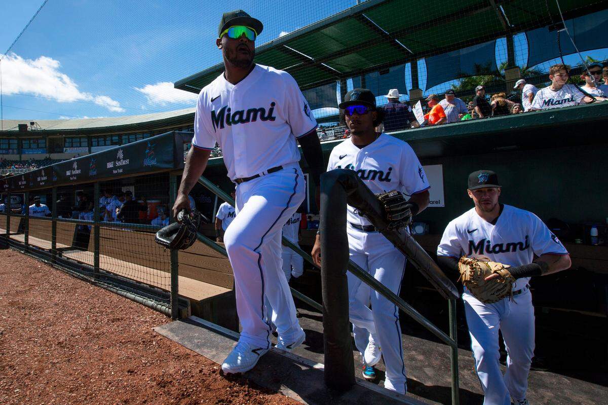 Miami Marlins catcher Brian Navarreto (87), outfielder Jerar Encarnacion (89), and catcher BJ Lopez (86) exit the dugout before the start of a Spring Training game against the Washington Nationals at Roger Dean Chevrolet Stadium in Jupiter, Florida on Sunday, February 23, 2020.