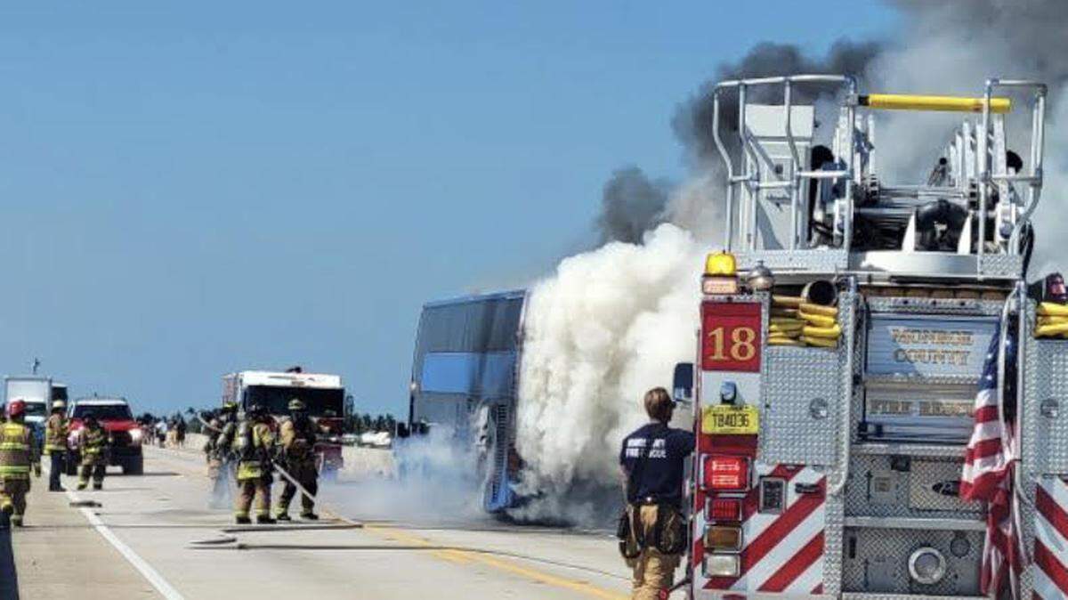 Firefighters work to put out flames and smoke coming from a burning tour bus in the city of Layton in the Florida Keys Tuesday, Feb. 28, 2023.