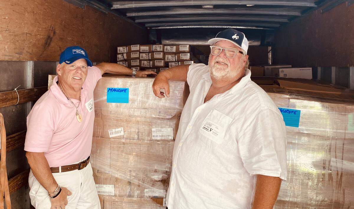 Mike Forster and Michael Rempe stand inside a truck containing donated meat from Cargill Protein.