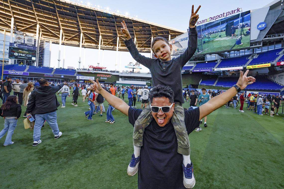 Wagner Vargas carries his son Max, 6, on his shoulders during Marlins Fan Fest at loanDepot park in Miami.