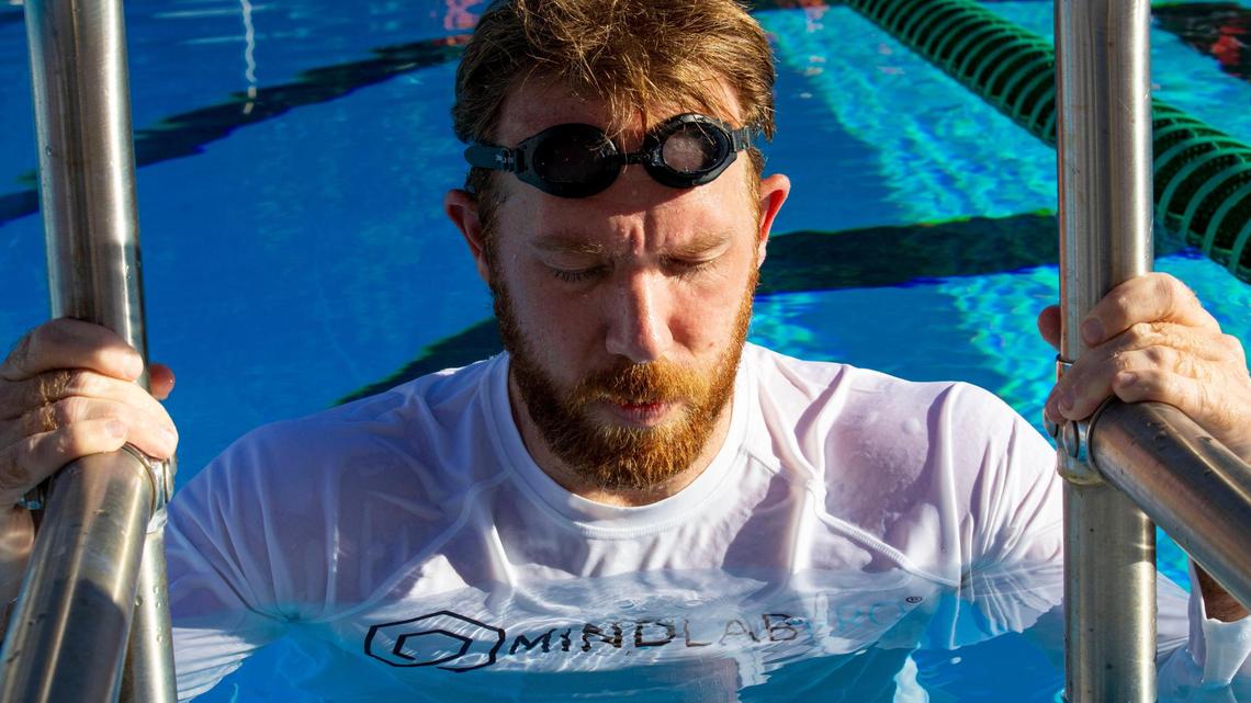 After memorizing the order of playing cards under water, Nelson Dellis rests at the edge of the pool and recreates the order of the cards in his mind before attempting to assemble it at a table.