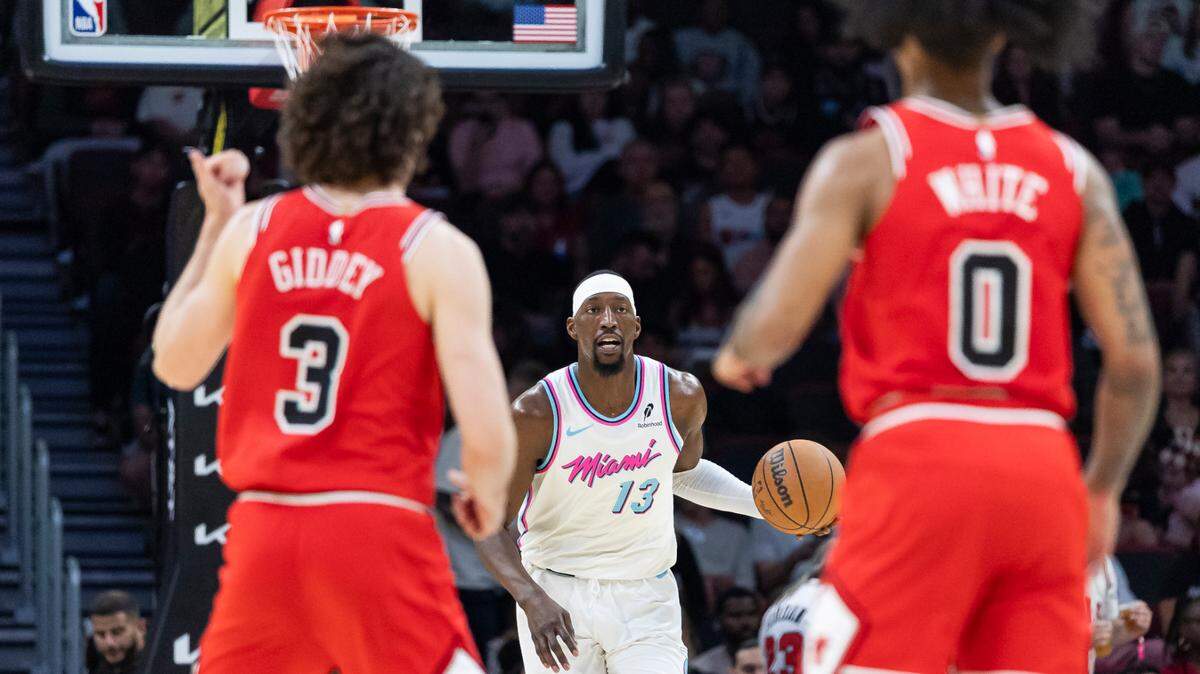 Miami Heat center Bam Adebayo (13) drives the ball as Chicago Bulls guards Josh Giddey (3) and Coby White (0) defend in the second half of their NBA game at the Kaseya Center on March 8, 2025, in Miami.
