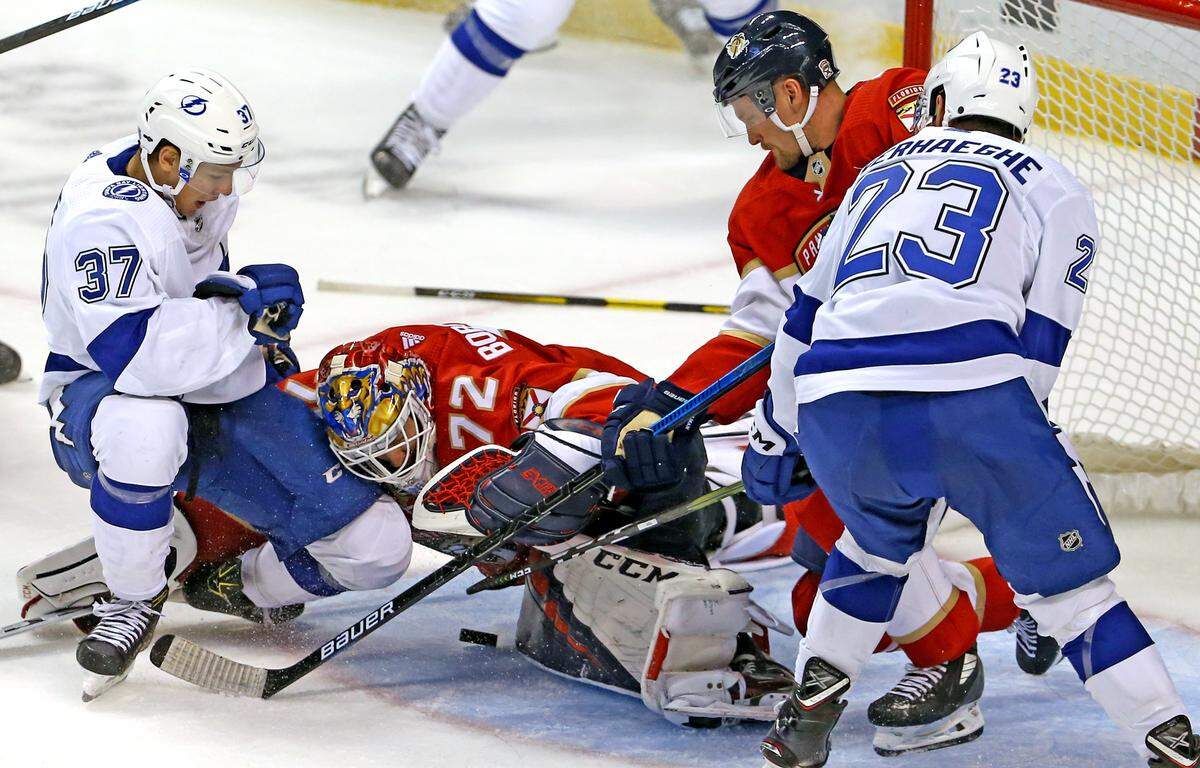 Florida Panthers goalie Sergei Bobrovsky (72) go for the puck as he defends the goal against Tampa Bay Lightning center Yanni Gourde (37)  and center Carter Verhaeghe (23) during the third period&nbsp;of the Panthers home opener NHL regular season hockey game at the BB&T Center on Saturday, October 5, 2019 in Sunrise.