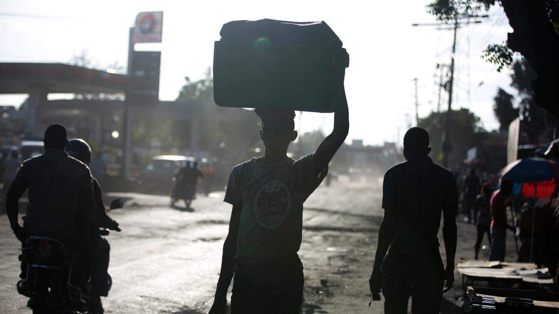 People walk in the street on the second day of a nationwide, general strike in Port-au-Prince, Haiti, early Tuesday, July 10, 2018. While some opposition leaders have called off the strike for Tuesday, most businesses remained closed following days of violent protests against a 50 percent fuel hike, part of a plan endorsed by the IMF to modernize the economy, and calls for the resignation of President Jovenel Moise, whose government suspended the hike. (AP Photo/Dieu Nalio Chery)