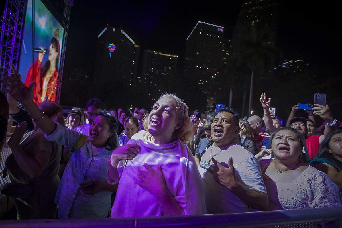 Zully Mar Vidal, second from left, sings along with friends during a performance.