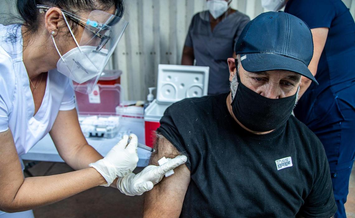 Nurse Sulem Yague gives a shot of the (J&J/Janssen) COVID-19 vaccine to Reynol Perez, a homeless man who is living in North Miami Avenue in downtown Miami, Friday, May 21, 2021.