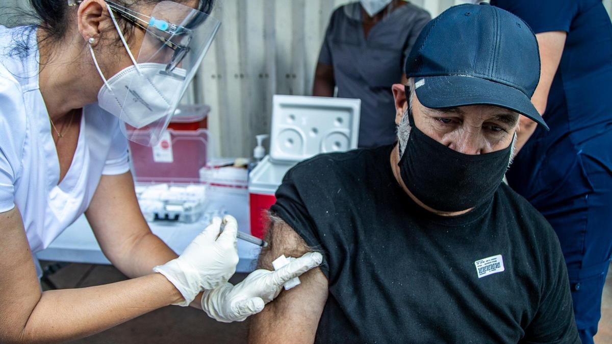 La enfermera Sulem Yague aplica una inyección de la vacuna contra el COVID-19 a Reynol Pérez, un indigente que vive en North Miami Avenue, en el downtown de Miami,