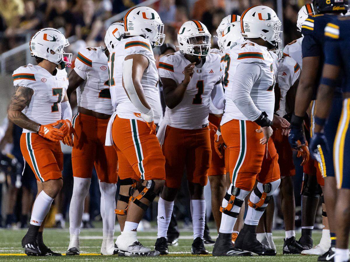 Miami Hurricanes quarterback Cam Ward (1) talks with his teammates inside of a huddle in the first half of his NCAA college football game against the California Golden Bears at the California Memorial Stadium on Saturday, Oct. 5, 2024, in Berkeley, Calif.