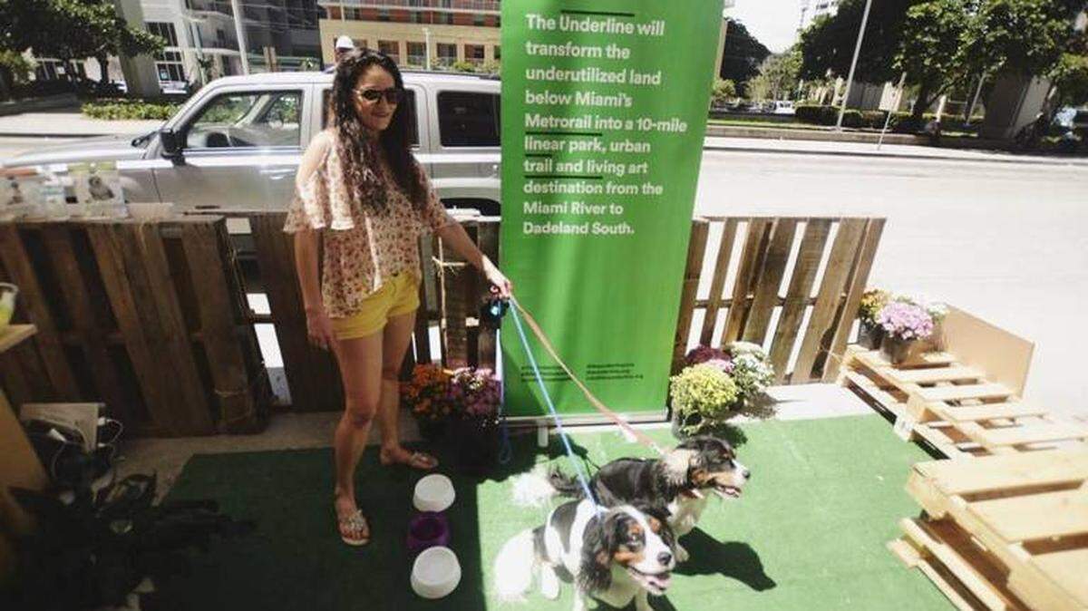 A woman and her dog enjoy a pop-up dog café during PARK(ing) Day, near downtown Miami, in September 2020. The event was created by Florida International University students in collaboration with The Underline.