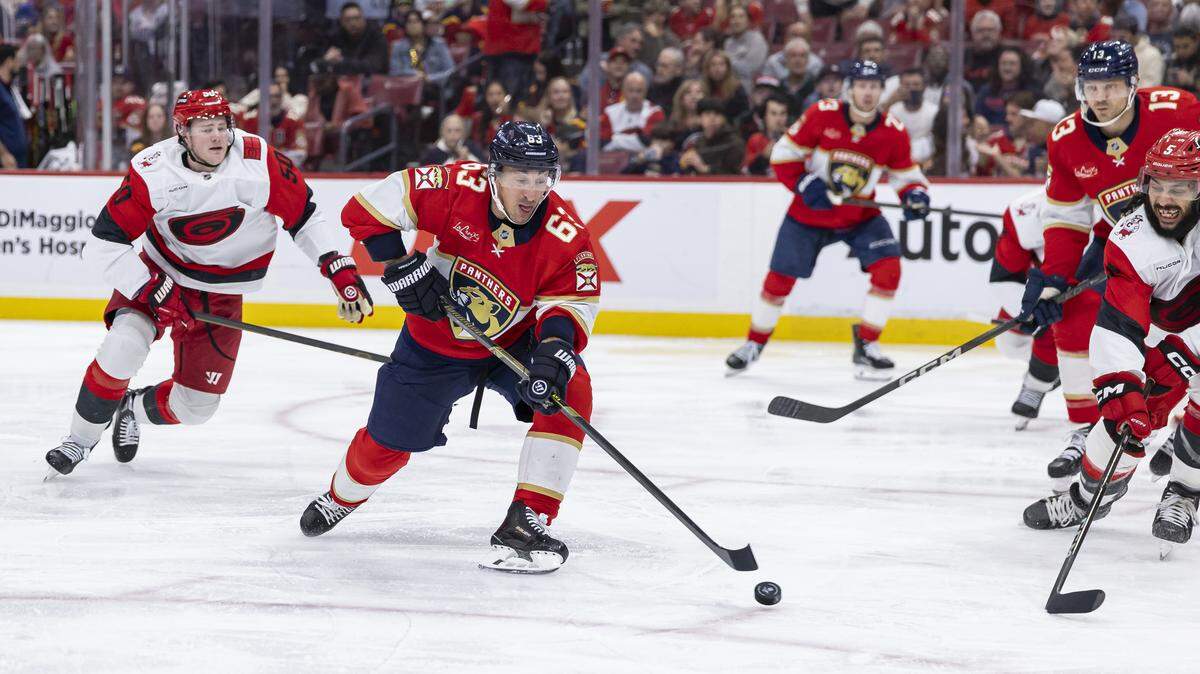 Florida Panthers left wing Brad Marchand (63) skates with the puck as Carolina Hurricanes defenseman Jalen Chatfield (5) defends in the second period of their NHL game at Amerant Bank Arena on Friday, Dec. 19, 2025, in Sunrise, Fla.