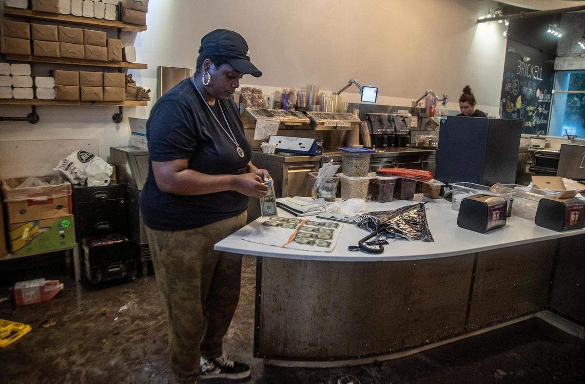 A J Anderson shift leader at Raw Juce store sets some dollar bills to dry that got wet due to a massive rainfall from the Tropical Storm Alex that caused serious floods leaving several businesses flooded in the Brickell area on Saturday June 4, 2022.
