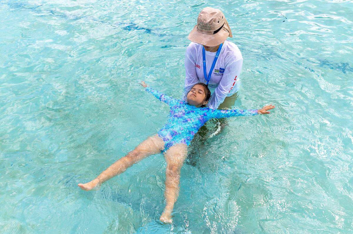 Yara Sanchez, 21, a Miami-Dade county life guard, teaches Alyssa Roche, a kindergartener from Rockway Elementary School, how to swim at Rockway Park Swimming Pool on Thursday, May 14, 2026, in Miami, Fla. The students are participants in Miami-Dade County's Zero Drowning initiative that aims to reduce children drowning.