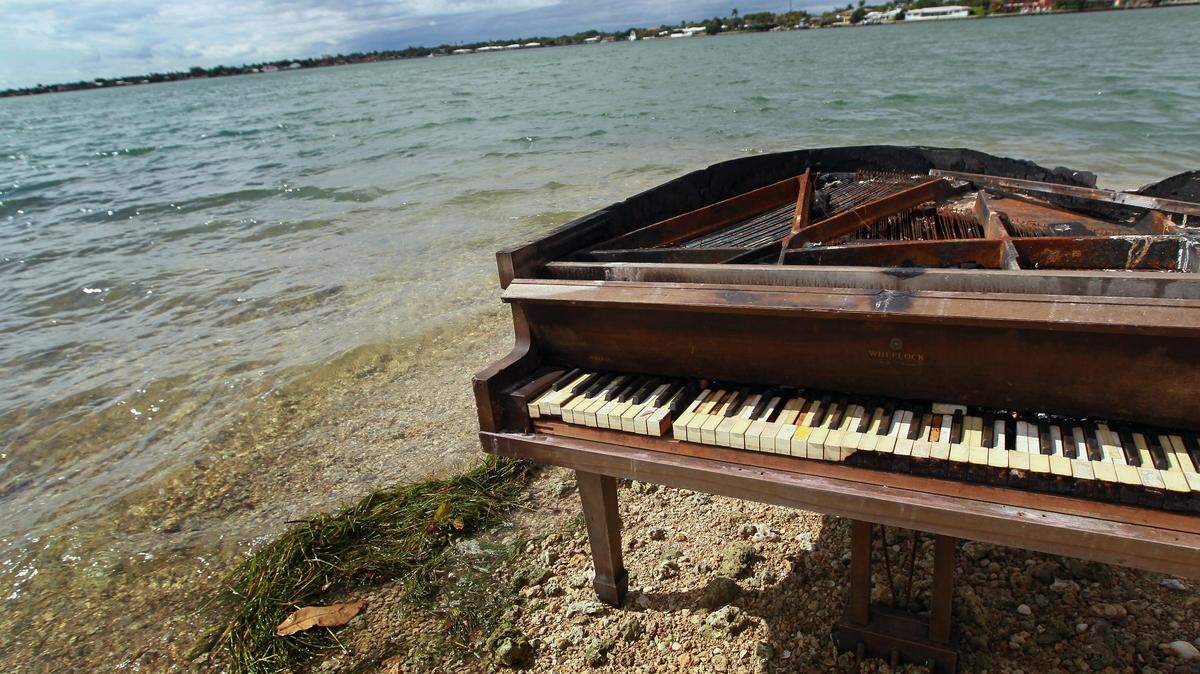 A grand piano is seen on a sandbar in Biscayne Bay on January 26, 2011 in Miami, Florida. The piano was charred from being burned.