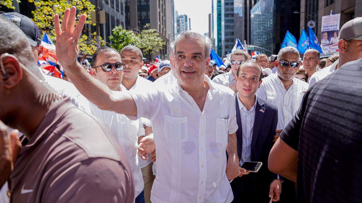 The president of the Dominican Republic, Luis Abinader (C), waves during the Dominican Day Parade on Sixth Avenue in New York on Aug. 13, 2023. Abinader was surrounded by crowds Sunday during the traditional Dominican Parade in New York, which brought together thousands of people along Sixth Avenue in an atmosphere of merriment.