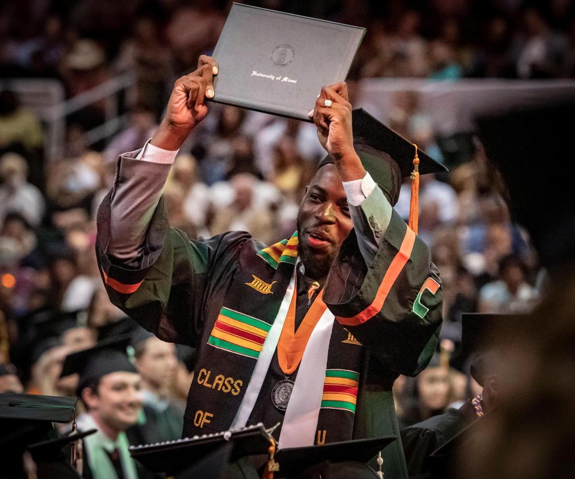 Ace Armand, 23, from Miami, flashes his diploma to his family at the University of Miami graduation ceremony on Friday morning, May 13, 2022, in Coral Gables.