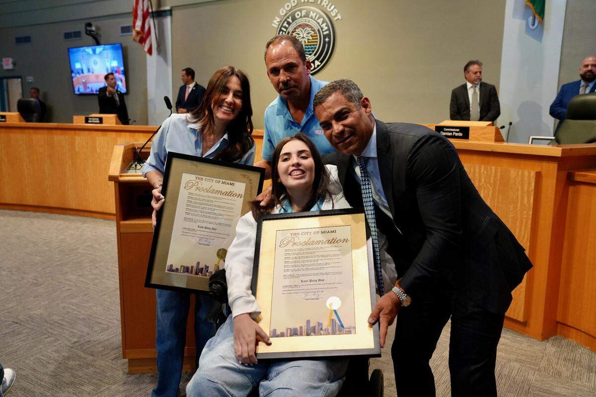 Kathya and Rudy Puig stand with Miami Mayor Francis Suarez and their daughter, Katerina Puig, on Thursday, July 10, 2025, at City Commission meeting. The city proclaimed the day in honor of Katerina, who continues to recover from injuries she sustained in a Sept. 4, 2022, boat crash in Biscayne Bay.