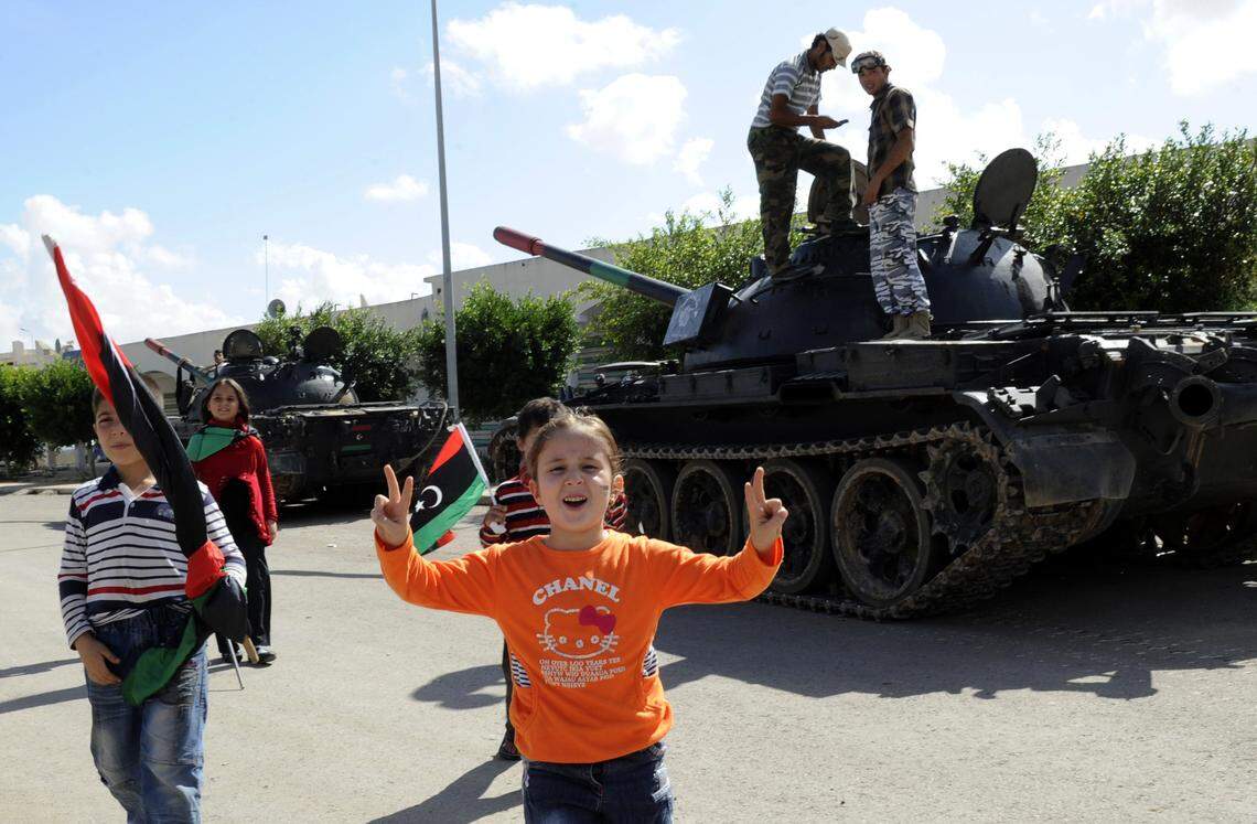 A young Libyan girl flashes the V-for-victory sign as she stands in front of a tank during a celebration in honour of the National Transitional Council (NTC) fighters in Misrata on October 28, 2011.  (PHILIPPE DESMAZES/AFP via Getty Images)