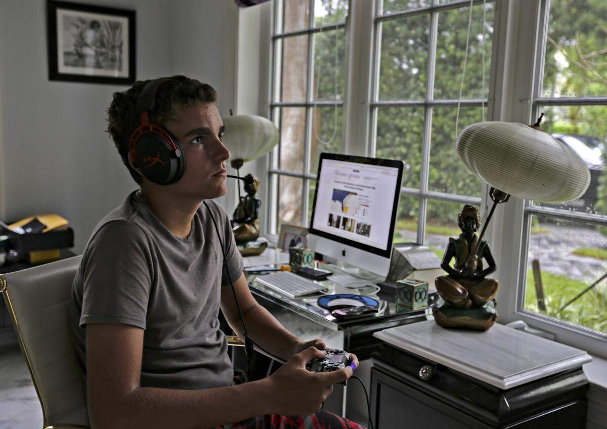Conrad Luce, 14, passes the time playing video games while he and his family passes the time waiting for the update on Hurricane Dorian’s path as it moved slowly on a northern track about 100 miles off of Palm Beach, Florida on Tuesday, September 3, 2019.