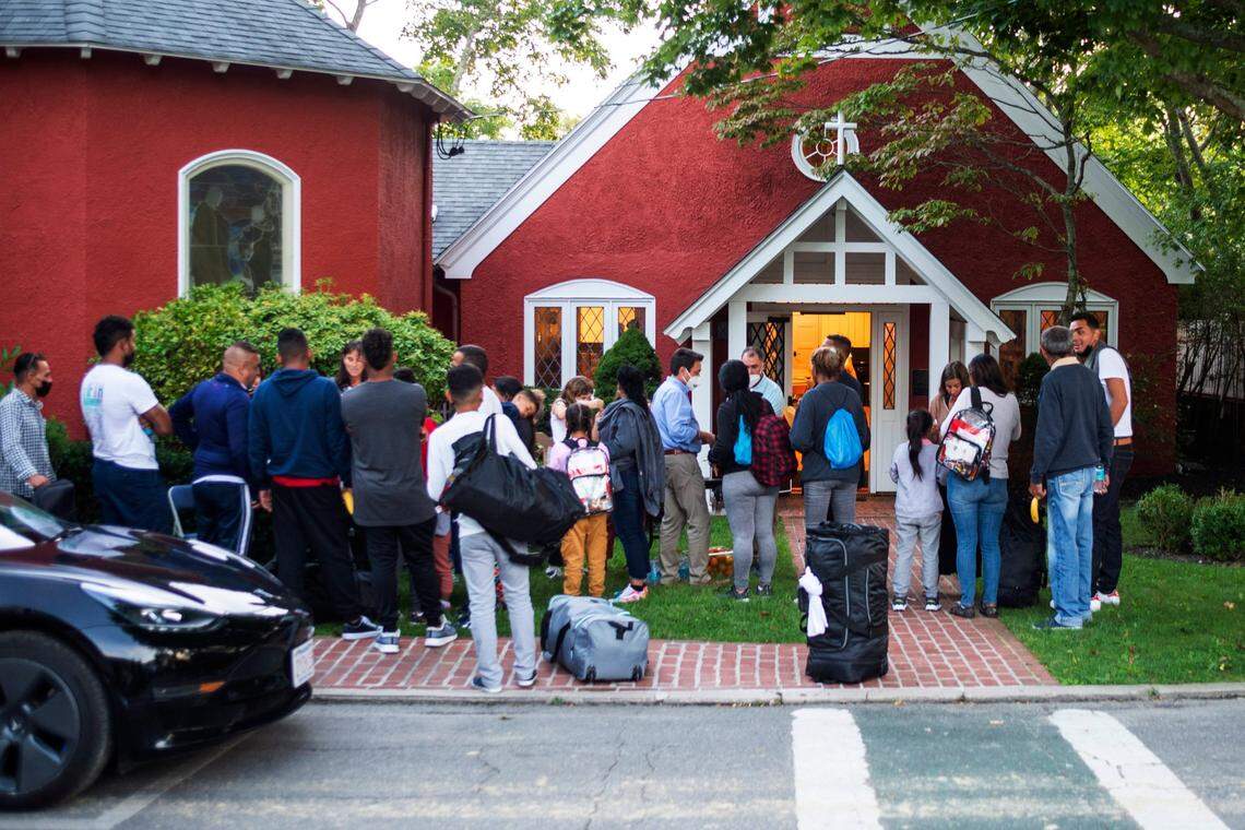 Immigrants gather with their belongings outside St. Andrew’s Episcopal Church, Wednesday, Sept. 14, 2022, in Edgartown, Mass., on Martha’s Vineyard.