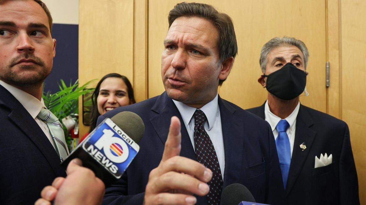 En esta foto del lunes 25 de mayo de 2021, DeSantis responde a la pregunta de un reportero de la televisión local después de haber firmado la legislación para hacer más difícil que las empresas de redes sociales castiguen a los usuarios que violan los términos de los acuerdos de servicio dentro del edificio MARC de la FIU, en Miami, Florida.